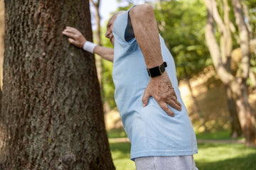 senior man suffers from pain in lower back leaning