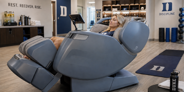 Student athlete relaxing in a massage chair inside an athletic recovery room.