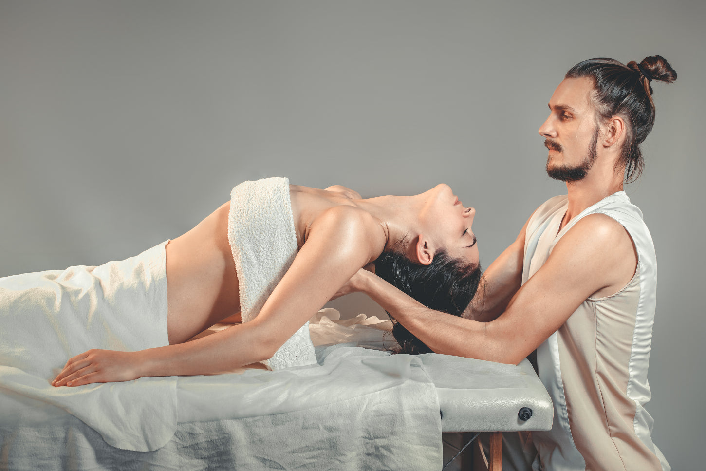 man performs massage and chiropractic adjustment to female client