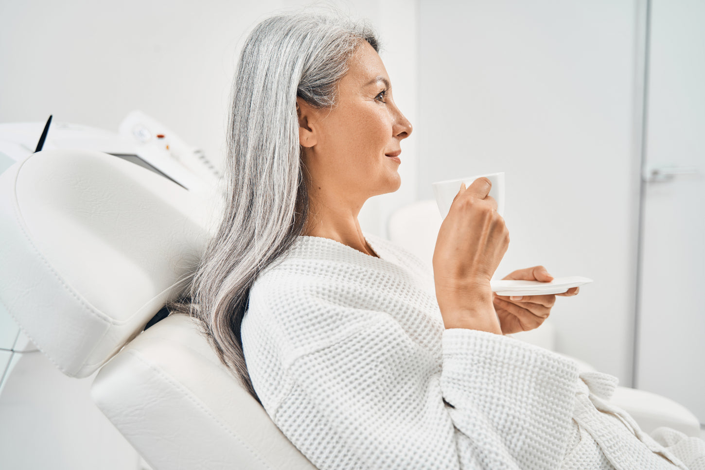 older-lady-sipping-tea-while-experiencing-massage-for-senior-at-home